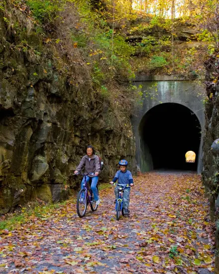 Two people biking through a tunnel